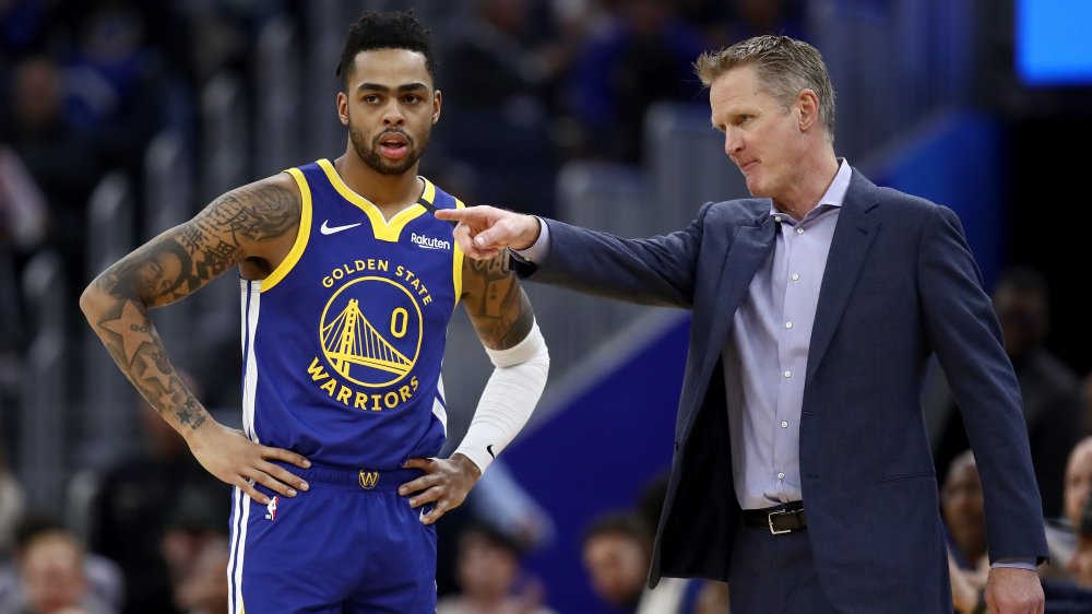 D'Angelo Russell # 0 de los Golden State Warriors habla con el entrenador en jefe Steve Kerr de los Golden State Warriors durante su juego contra los Utah Jazz