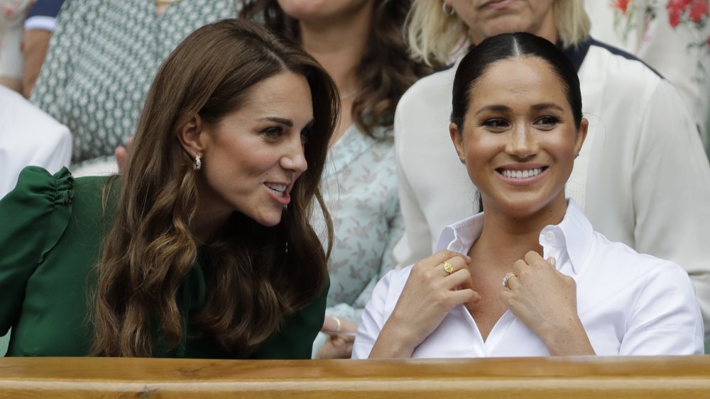 La británica Catherine (L), duquesa de Cambridge y la británica Meghan, duquesa de Sussex, observan a la rumana Simona Halep jugando contra la jugadora estadounidense Serena Williams durante la final de singles femeninos en el día doce del Campeonato de Wimbledon 2019