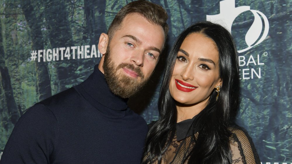 Artem Chigvintsev y Nikki Bella posando en el evento FIGHT4THEAMAZON