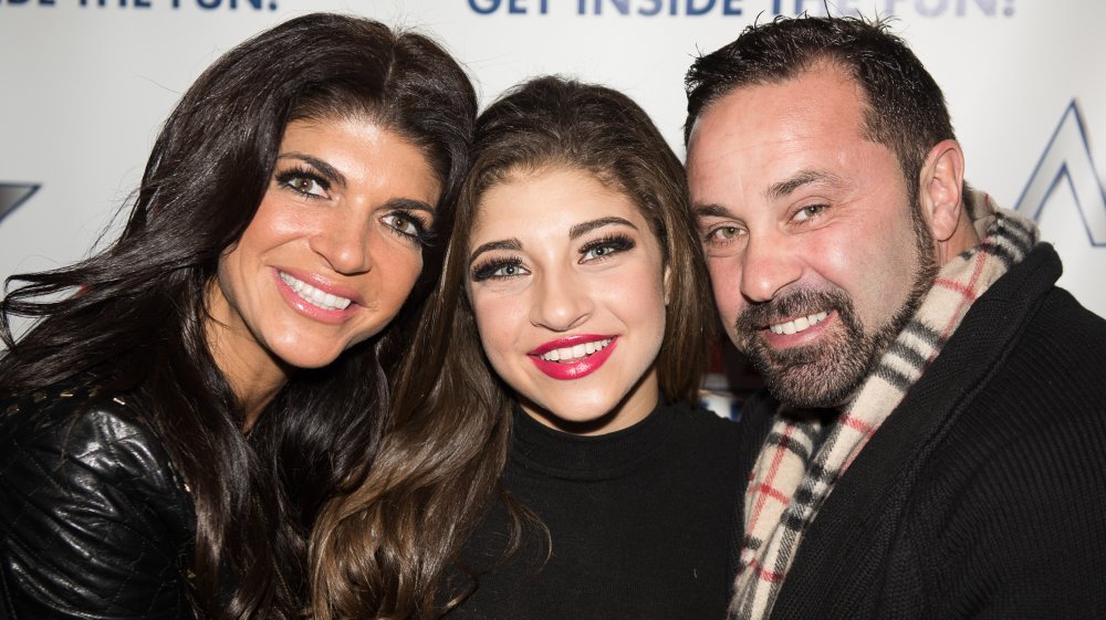 Teresa Giudice, Gia Giudice y Joe Giudice sonriendo y abrazándose en un evento de alfombra roja 