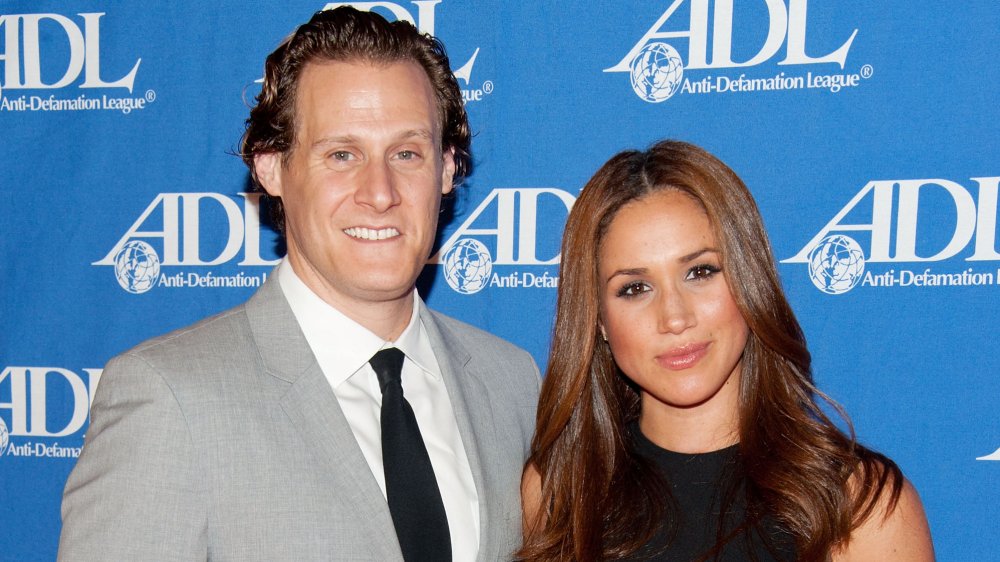 Trevor Engelson y Meghan Markle, sonriendo