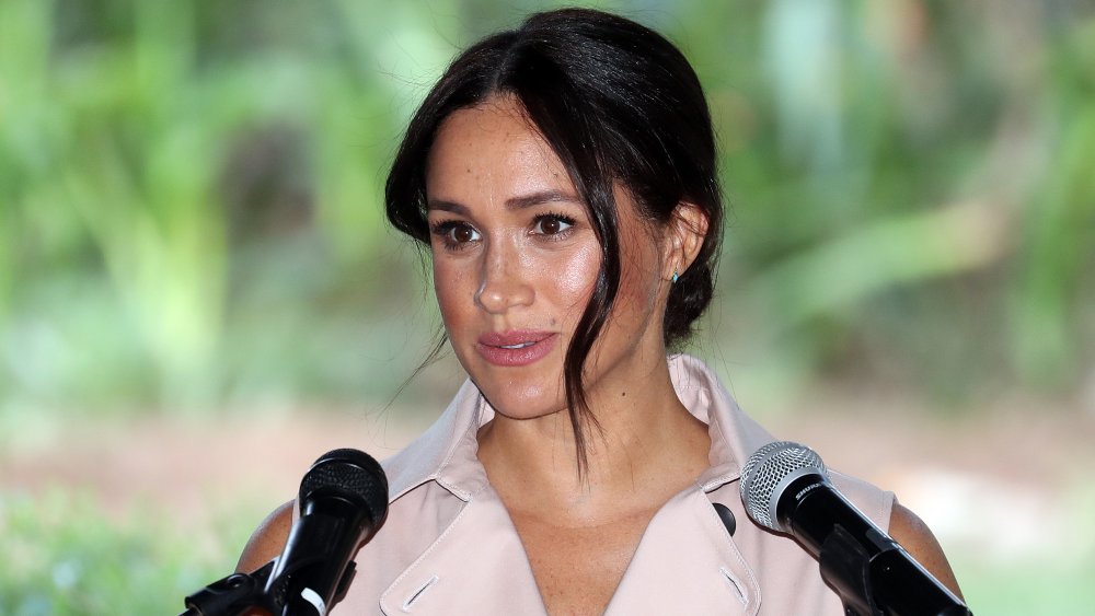 Meghan Markle hablando por dos micrófonos.