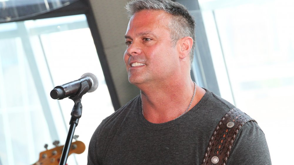 Troy Gentry delante de un micrófono en el escenario