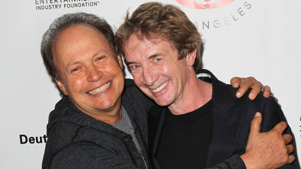 Billy Crystal y Martin Short sonríen y se abrazan en la alfombra roja