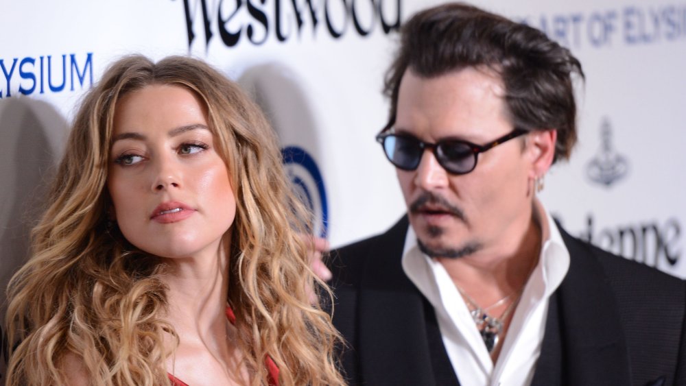 Amber Heard y Johnny Depp miran fuera de cámara