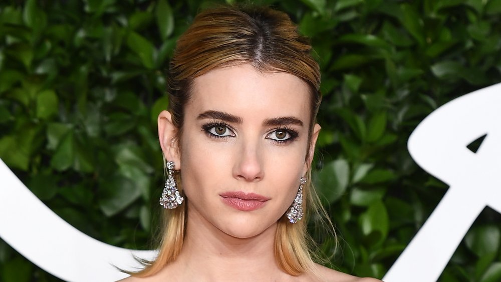 Emma Roberts posando en la alfombra roja con una expresión neutral