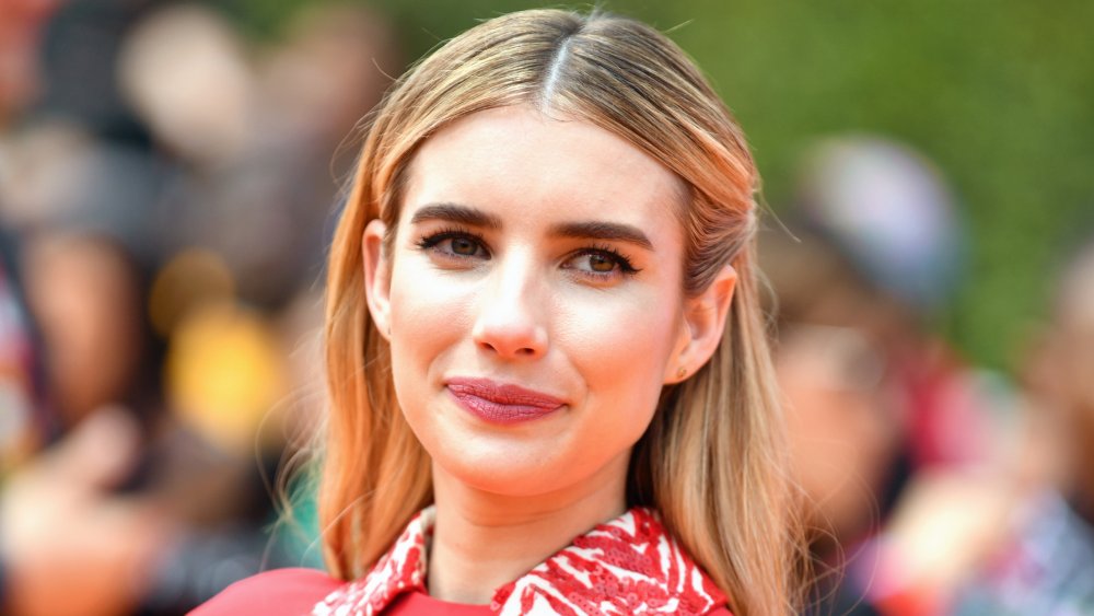 Emma Roberts sonriendo y mirando a un lado en un evento