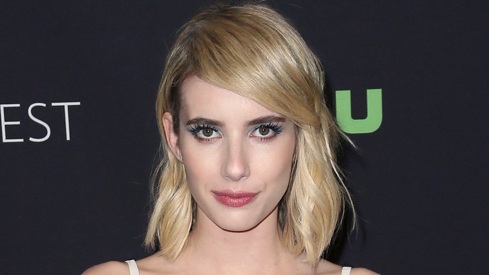 Emma Roberts mirando directamente a la cámara con una expresión neutral