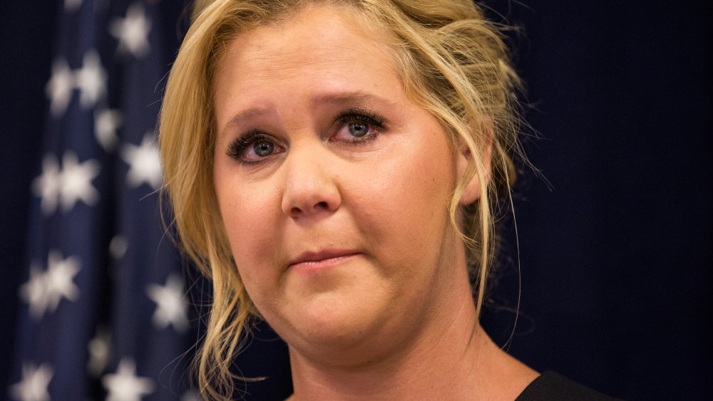 Amy Schumer se ve emocionada en una conferencia de prensa con el senador estadounidense Chuck Schumer 