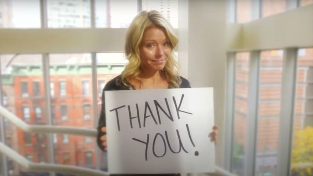 Kelly Ripa sosteniendo un cartel de "gracias"