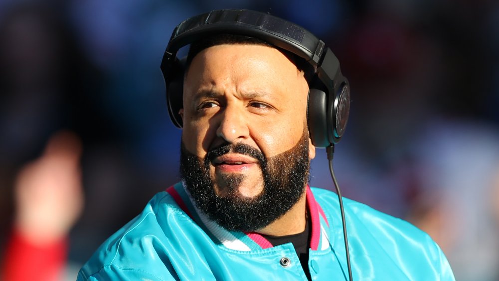 DJ Khaled con auriculares y chaqueta bomber azul