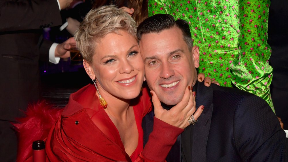 Pink sosteniendo la barbilla de Carey Hart, ambos sonriendo