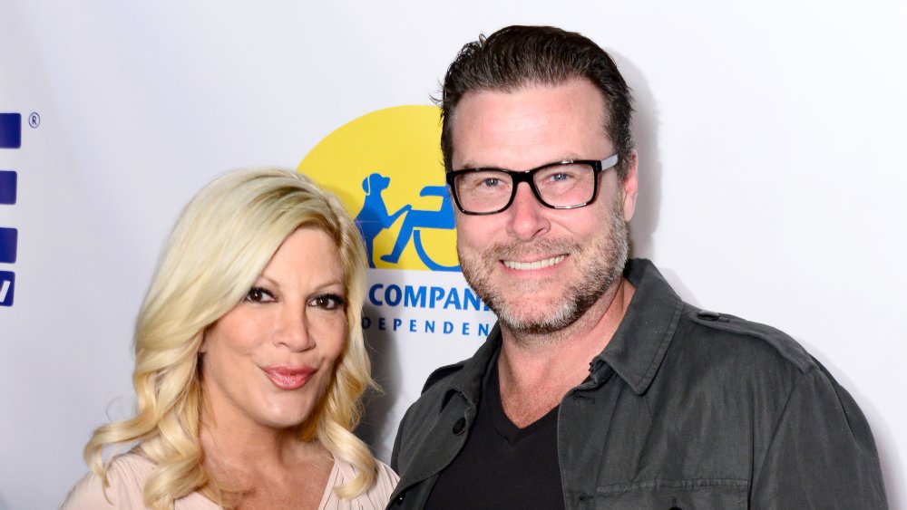 Tori Spelling y Dean McDermott, ambos posando y sonriendo.