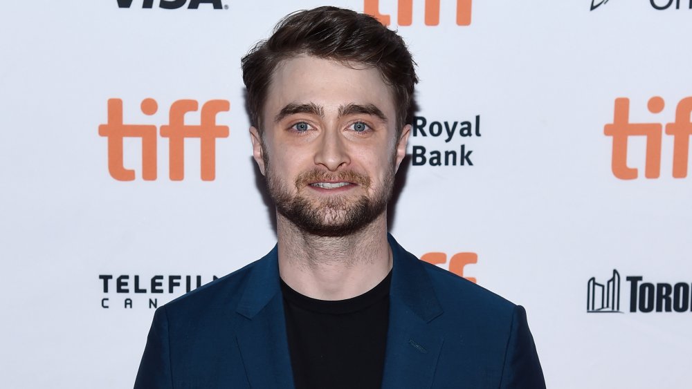 Daniel Radcliffe sonriendo a la cámara en la alfombra roja