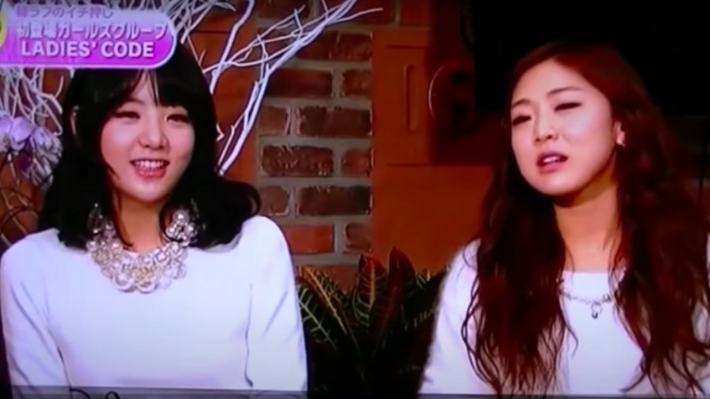 Kwon Ri-sae, Go Eun-bi hablando durante una entrevista, ambos vestidos con tops blancos