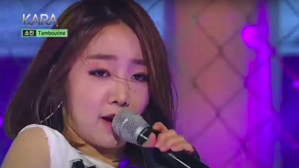 Ahn So-jin cantando durante la competencia del Proyecto Kara, vistiendo una camiseta sin mangas blanca