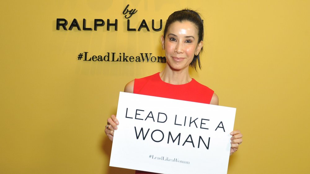 Lisa Ling con un cartel de "Plomo como una mujer"