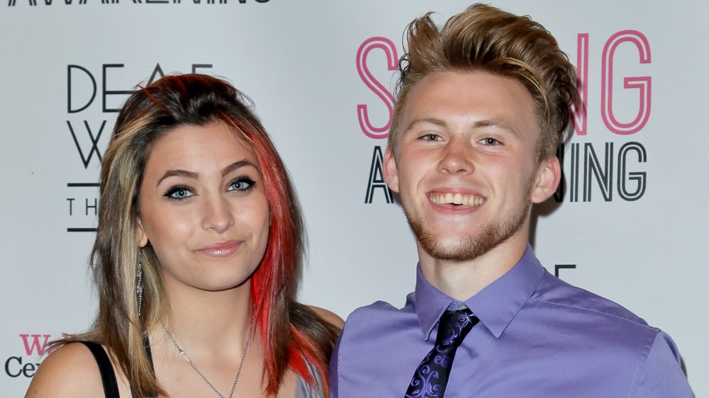 Paris Jackson sonriendo con el pelo veteado de rojo, posando con el entonces novio Chester Castellaw