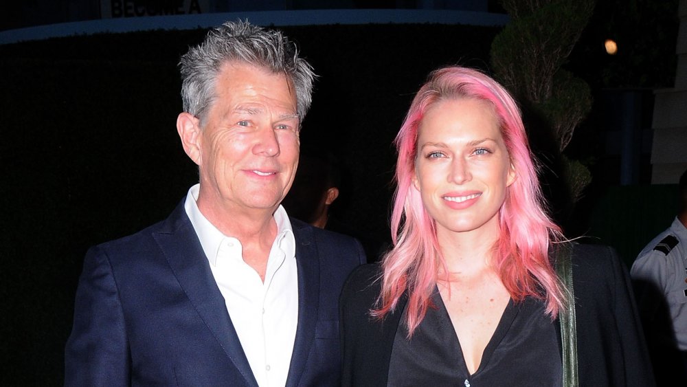 David Foster en blazer azul y camisa blanca, Erin Foster con cabello rosado y atuendo negro, posando juntos en un evento