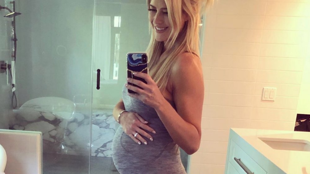 Christina Anstead posando para una selfie mientras se toca el vientre embarazado