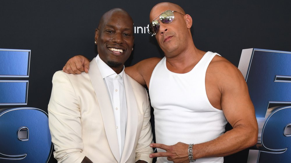 Tyrese Gibson y Vin Diesel, ambos de blanco y posando juntos en el estreno de una película Fast & Furious