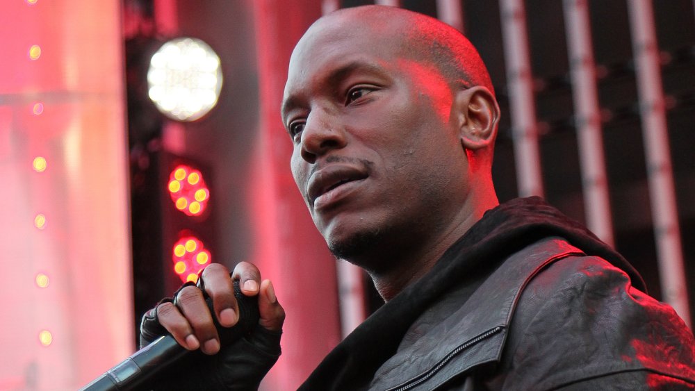 Tyrese Gibson en negro, mirando a la multitud durante una presentación en vivo