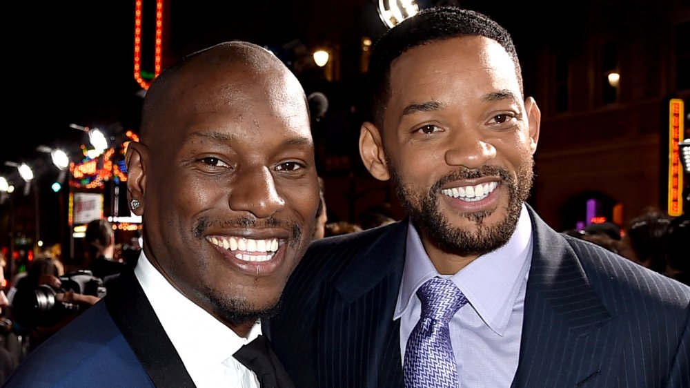 Tyrese Gibson y Will Smith, ambos con trajes azules y sonriendo en un evento con los brazos abrazados