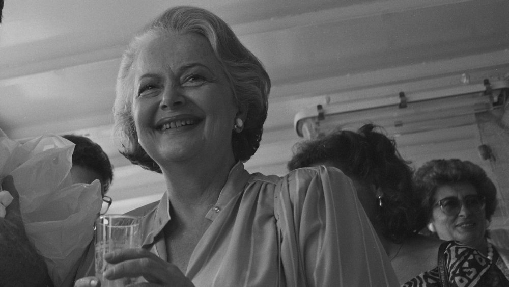 Foto en blanco y negro de Olivia de Havilland sonriendo y sosteniendo una copa