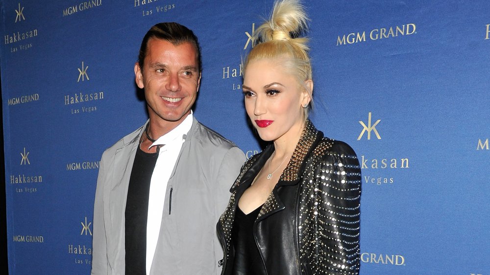 Gavin Rossdale sonriendo y con una chaqueta gris, y Gwen Stefani con una chaqueta de cuero negro con una expresión neutral, posando juntos