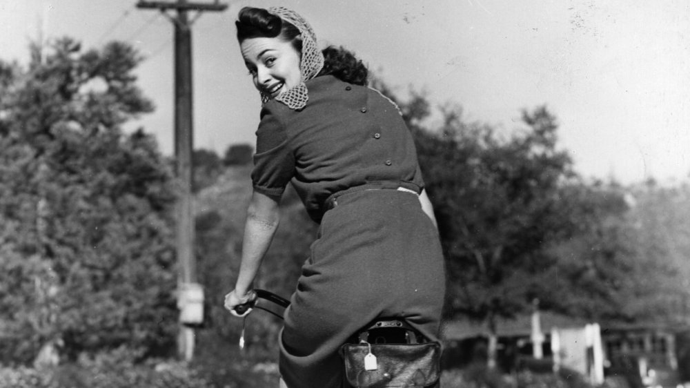 Foto en blanco y negro de Olivia de Havilland montando una bicicleta en 1938