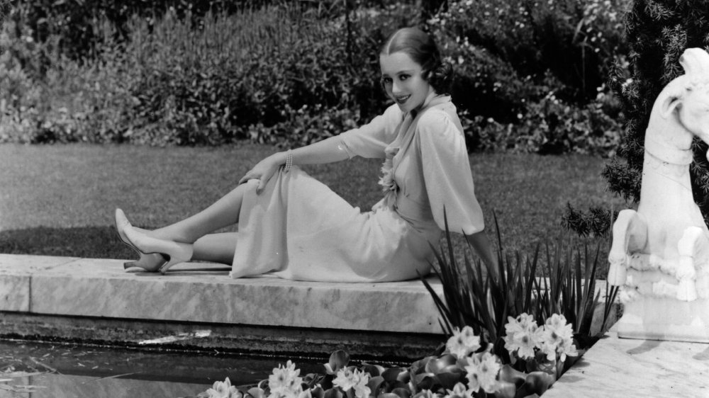 Foto en blanco y negro de Olivia de Havilland sentada en su jardín en 1938