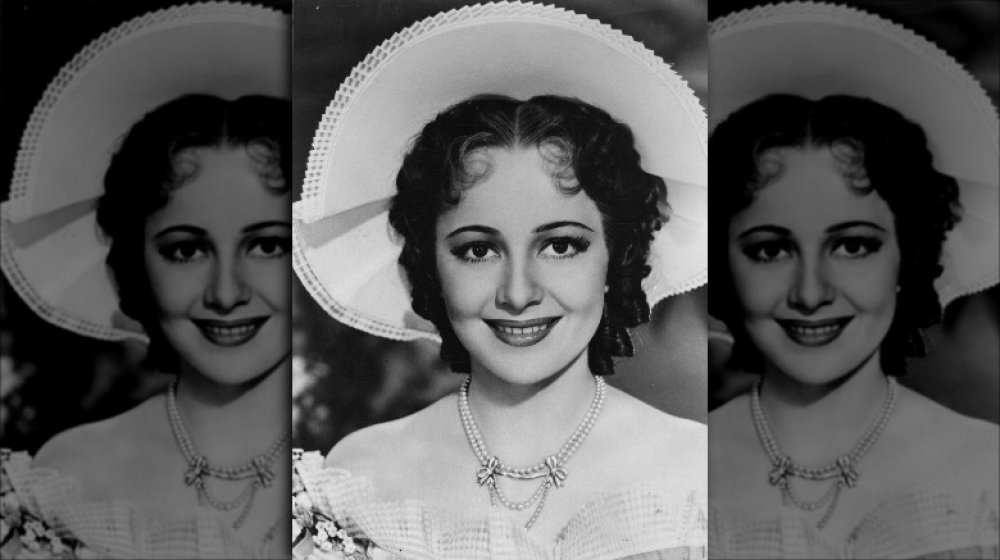 Foto en blanco y negro de Olivia de Havilland sonriendo, con un sombrero grande