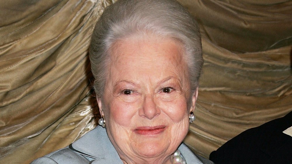 Olivia de Havilland con un traje azul y perlas, sonriendo en 2006