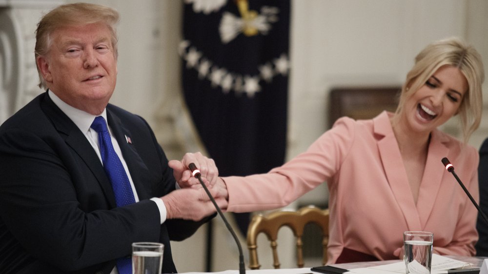 Donald Trump e Ivanka Trump riendo y dándose la mano durante una reunión