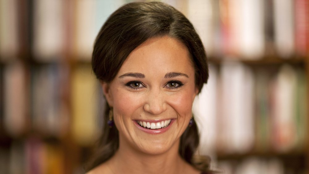 Pippa Middleton sonriendo mientras mira directamente a la cámara