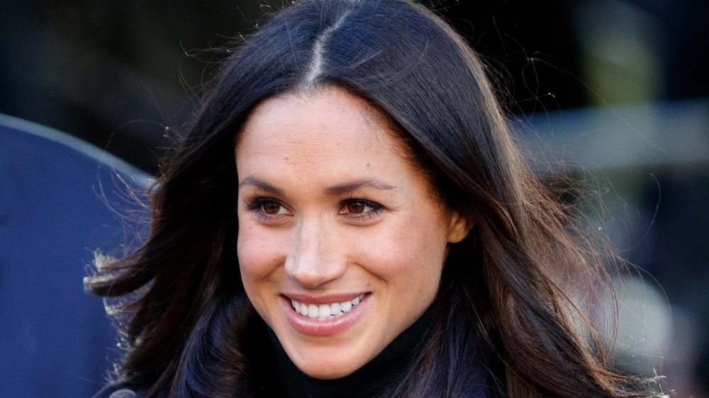 Meghan Markle sonriendo, cabeza a lado