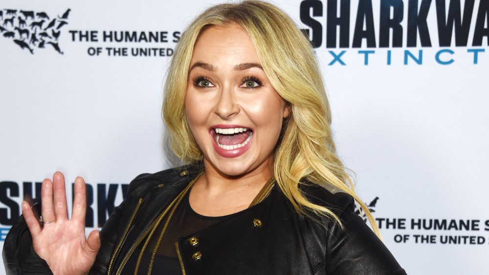 Hayden Panettiere sonriendo y saludando a la alfombra roja