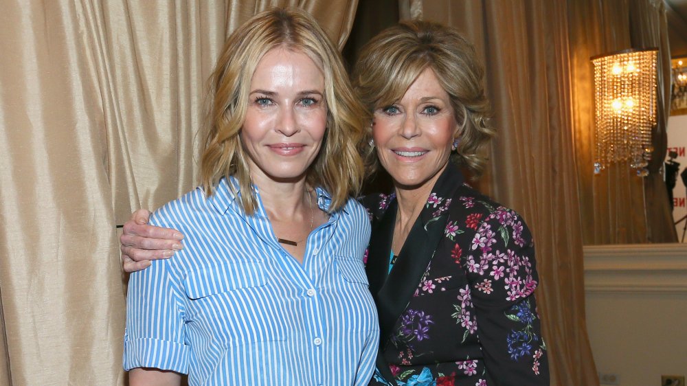 Chelsea Handler con una camisa abotonada a rayas azules y blancas, Jane Fonda con un blazer negro con estampado floral, posando en un almuerzo de Netflix en 2016