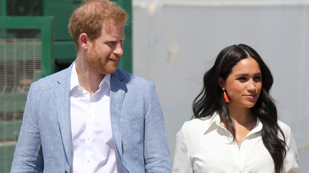 Príncipe Harry y Meghan Markle caminando afuera