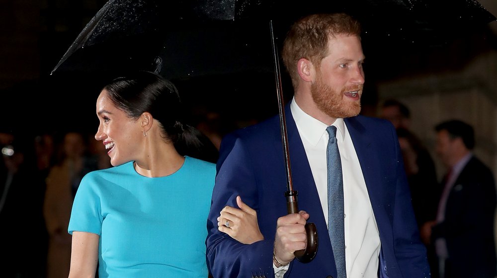 Meghan Markle y el príncipe Harry bajo un paraguas