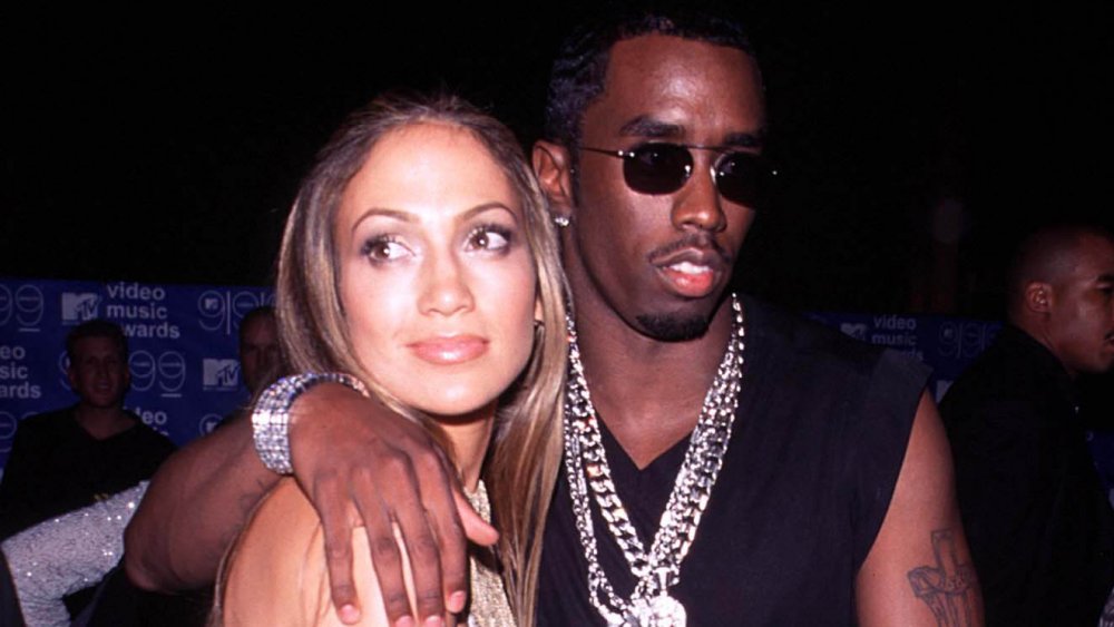 Jennifer Lopez, Sean Combs mirando en direcciones opuestas con expresiones neutrales en los MTV VMA de 1999