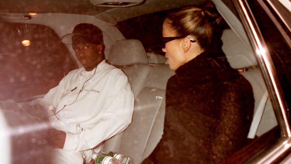 Sean Combs, Jennifer Lopez sentados muy separados en un auto juntos, ambos luciendo serios