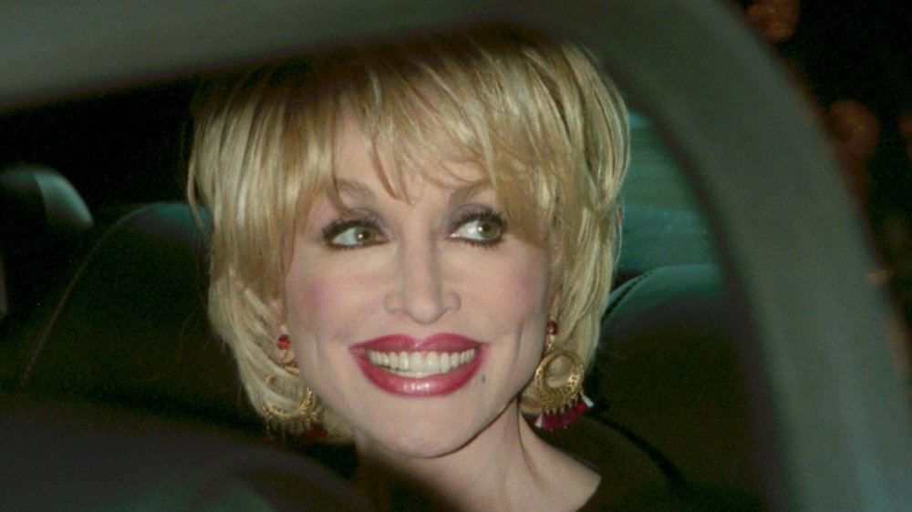 Dolly Parton sonriendo en un automóvil en 2000 a los 54 años