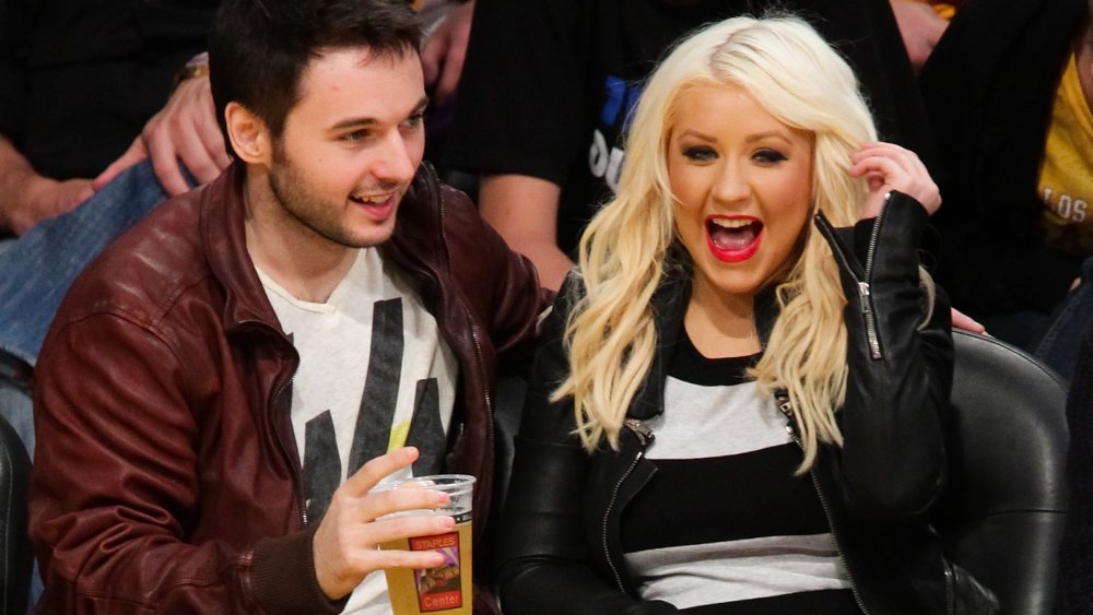 Matthew Rutler and Christina Aguilera sitting courtside at a Lakers game in 2012