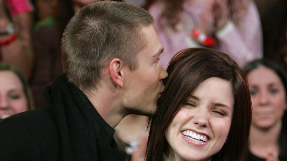 Chad Michael Murray besando la cabeza de una sonriente Sophia Bush