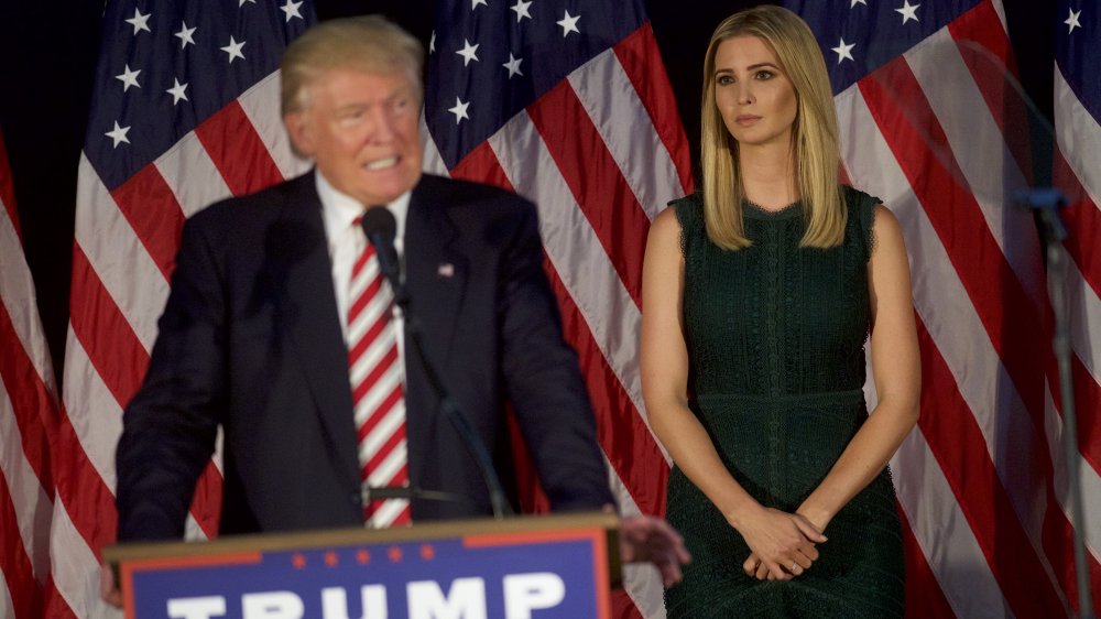 Ivanka Trump con un vestido verde, viendo a Donald Trump dar un discurso de campaña