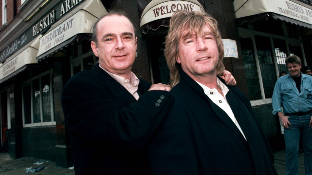 Los miembros de Status Quo Rick Parfitt y Francis Rossi posando juntos y sonriendo