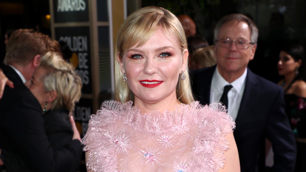 Kirsten Dunst con vestido rosa y lápiz labial rojo