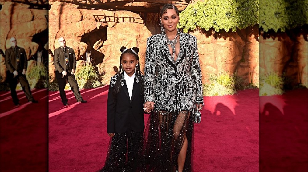 Blue Ivy y Beyoncé en trajes a juego, sosteniendo las manos en la alfombra roja