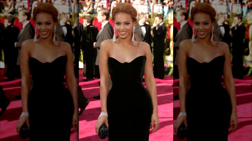 Beyoncé sonriendo con un vestido de terciopelo negro en los Oscar de 2005